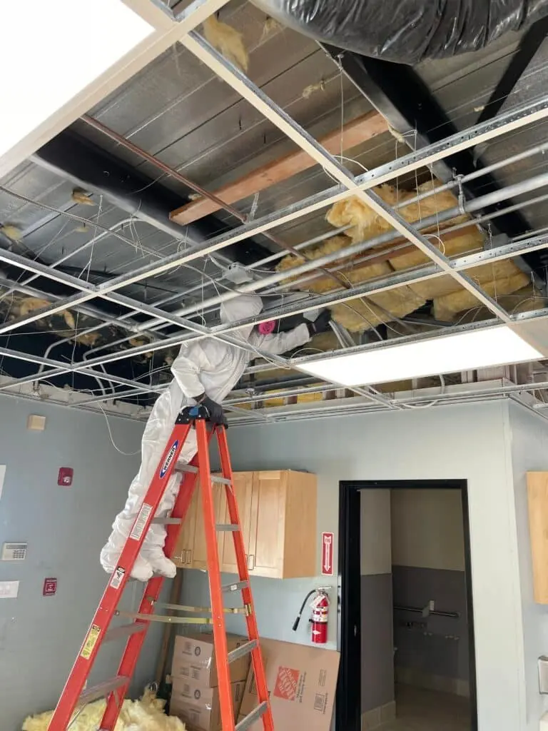 JW Home Care technician removing affected ceiling material inside containment